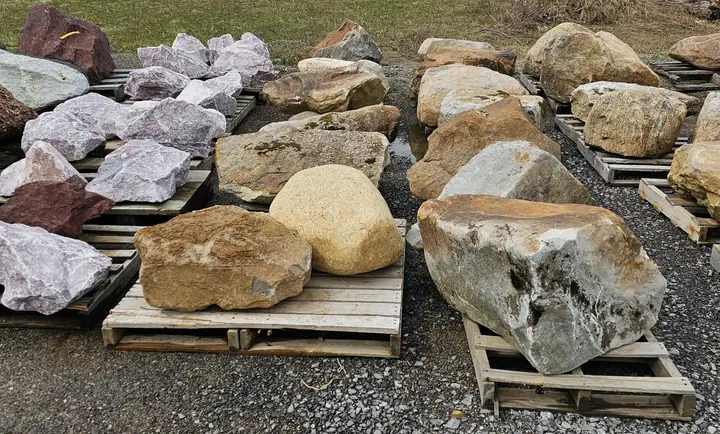 Pink, tan and grey decorative boulders on pallets
