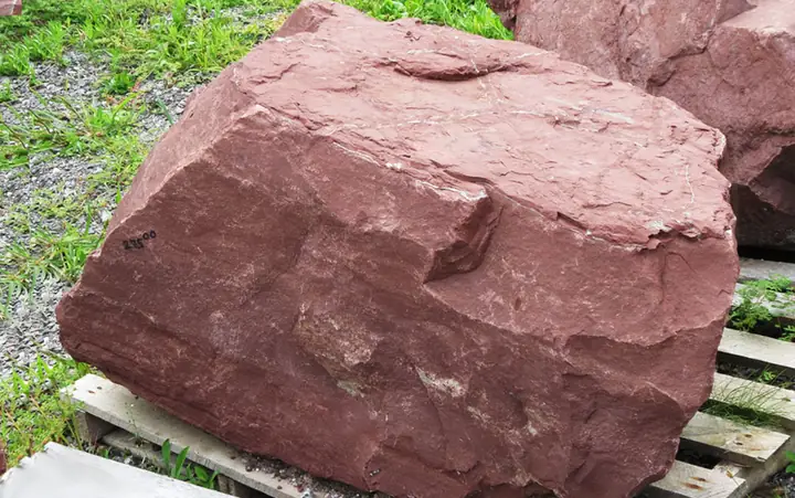 A large red boulder on a pallet