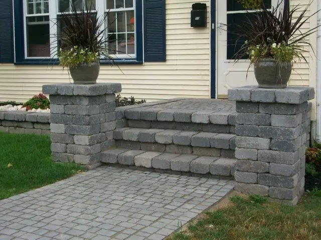 Block steps with two pillars and planters at a front door